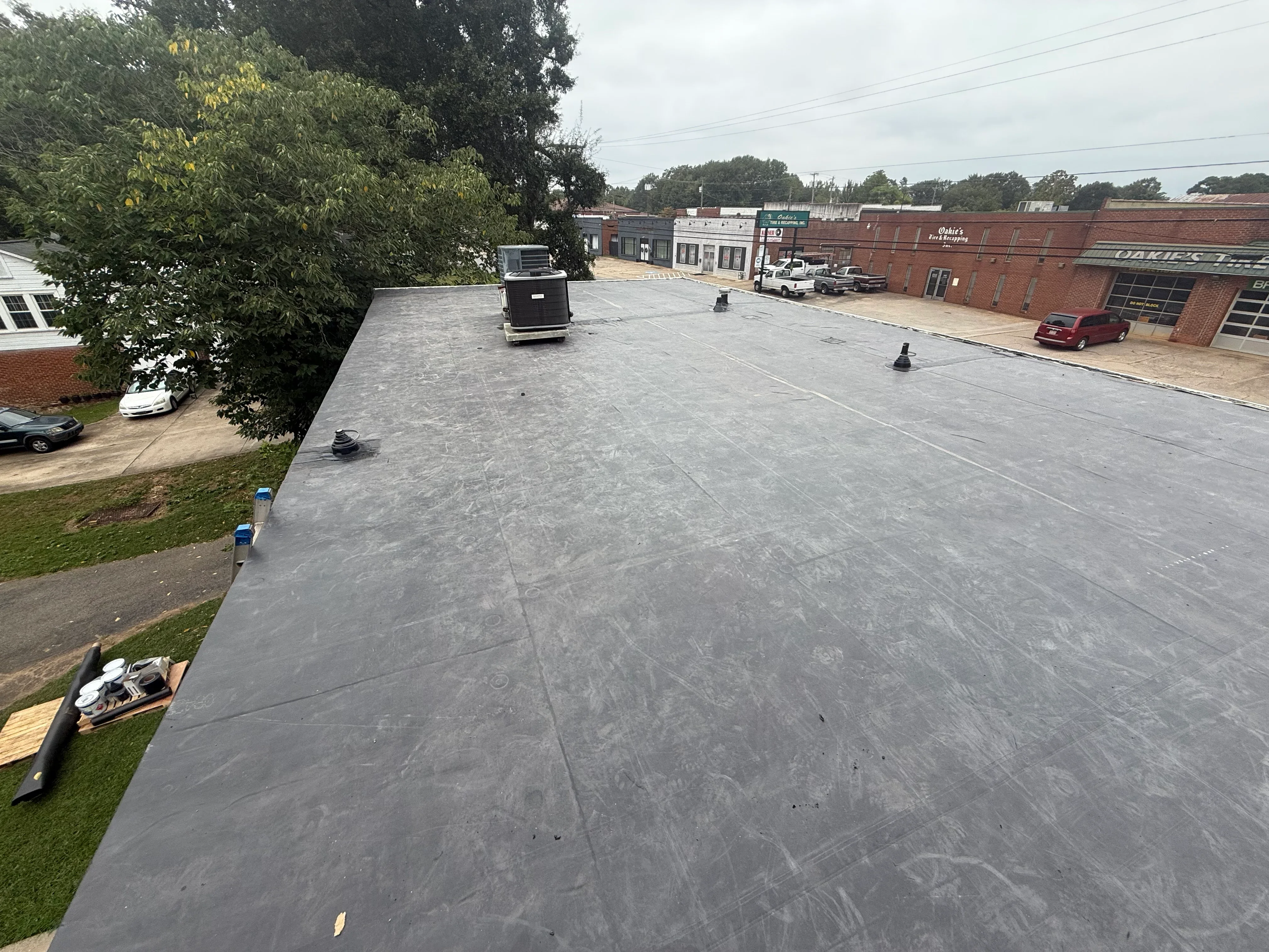 Newly installed gray flat roof membrane on commercial building with rooftop equipment