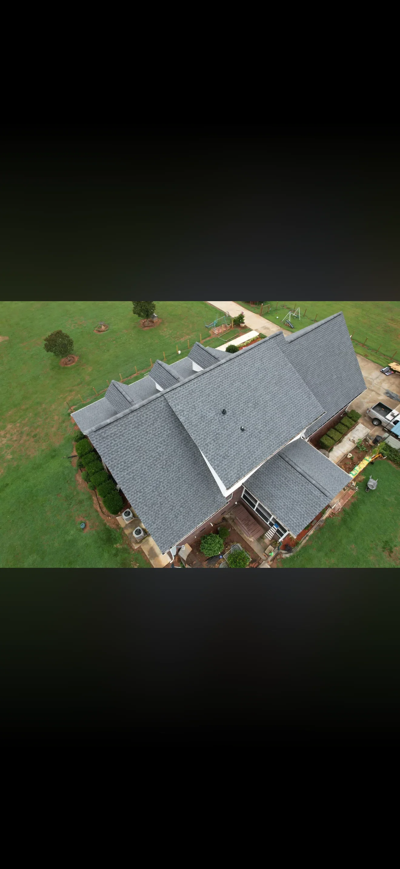 Aerial view of residential home with new gray asphalt shingle roof installation