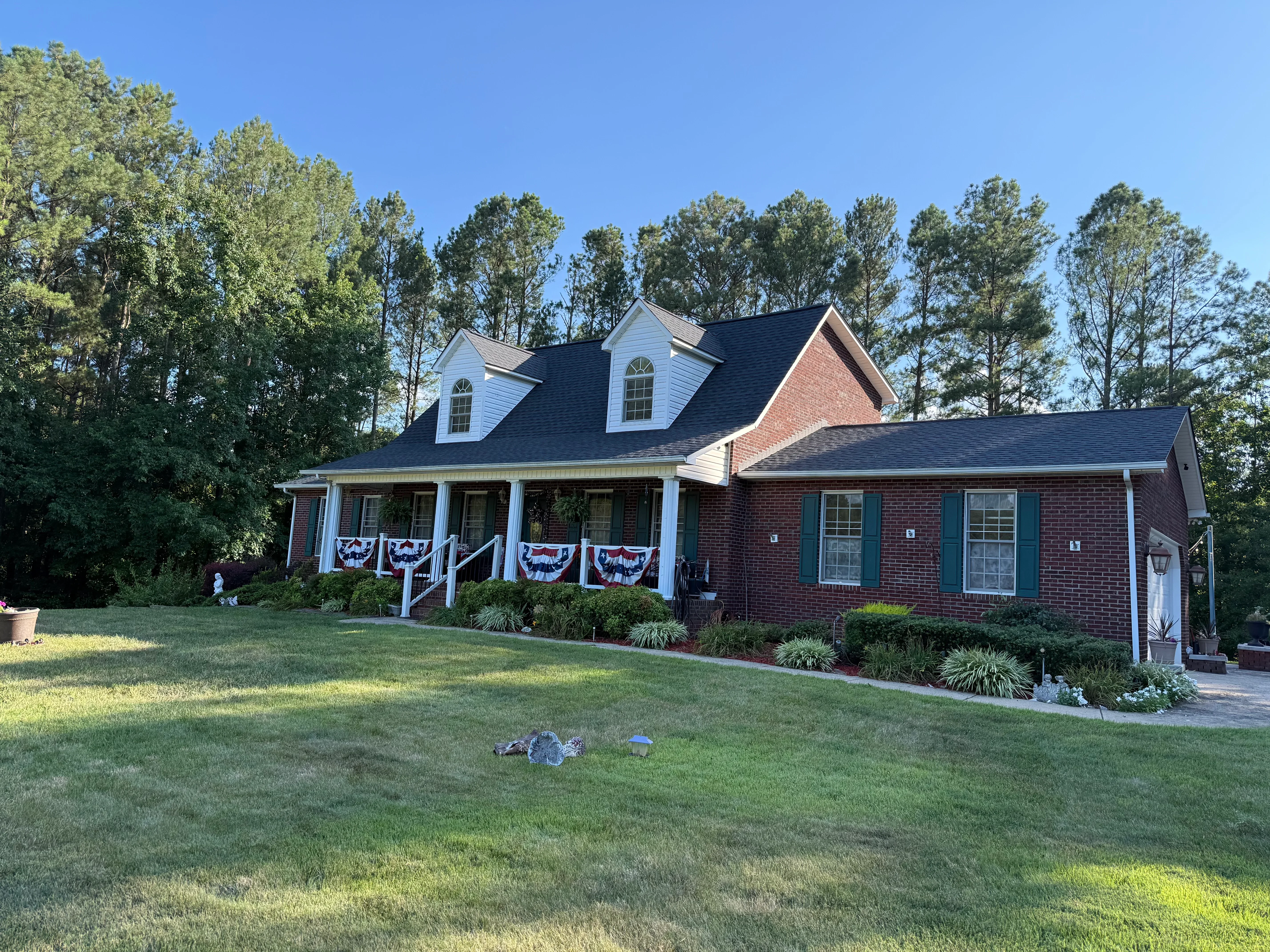 Brick colonial home with new dark shingle roof and white dormers in Shelby, NC